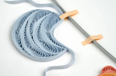 Quilled baby card with onesies, bibs, and hats hanging from a clothesline. A handmade card perfect for welcoming a newborn.