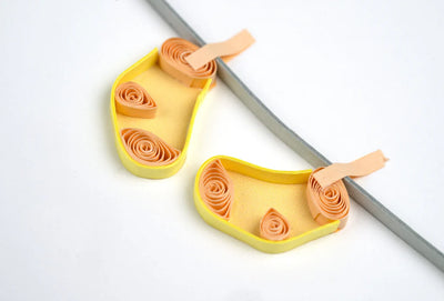Quilled baby card with onesies, bibs, and hats hanging from a clothesline. A handmade card perfect for welcoming a newborn.