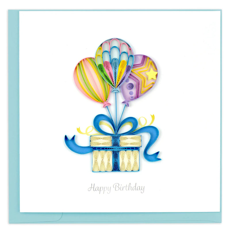 Quilled birthday card with three colorful balloons tied to a gift box with a blue bow and “Happy Birthday” message—playful and festive design.