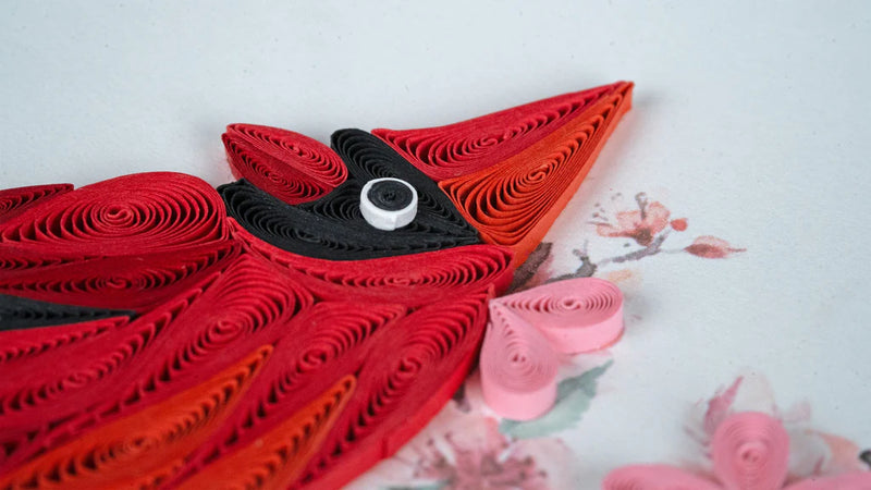 Quilled greeting card featuring a red cardinal perched among delicate pink cherry blossoms on a soft pastel background.