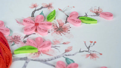 Quilled greeting card featuring a red cardinal perched among delicate pink cherry blossoms on a soft pastel background.