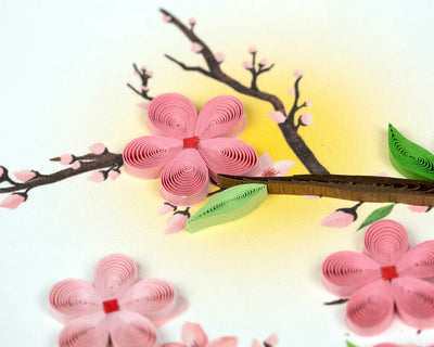 Handmade quilled card featuring pink cherry blossoms on tree branches, symbolizing renewal, spring, and beauty.