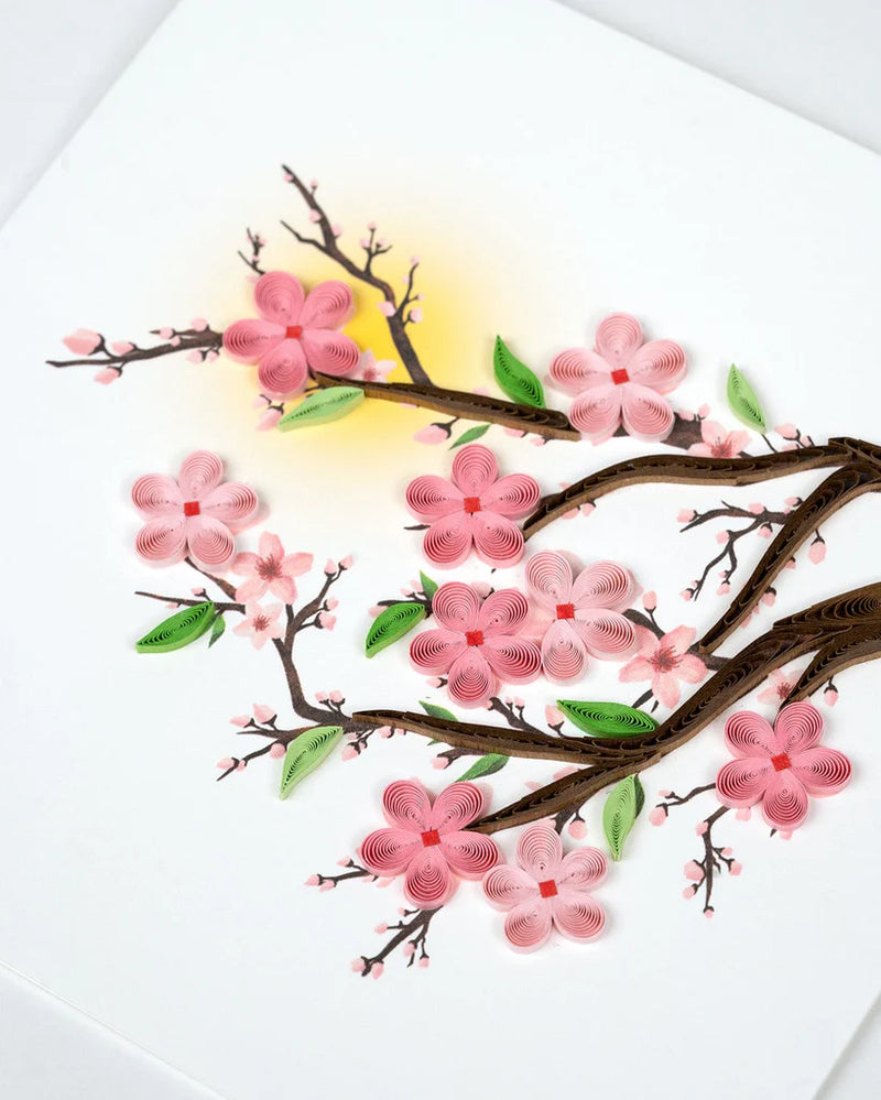 Handmade quilled card featuring pink cherry blossoms on tree branches, symbolizing renewal, spring, and beauty.