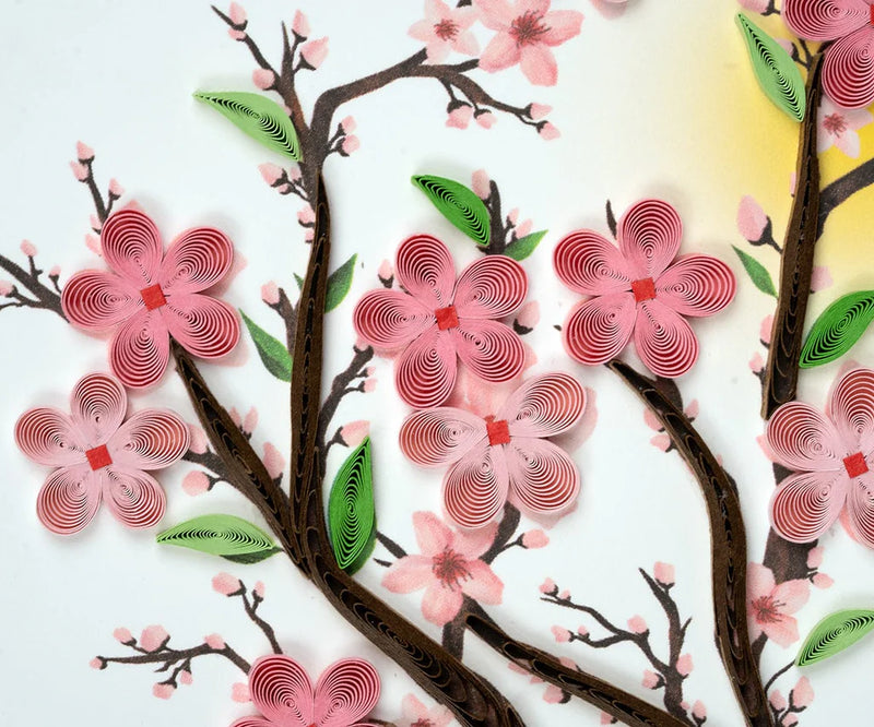 Handmade quilled card featuring pink cherry blossoms on tree branches, symbolizing renewal, spring, and beauty.