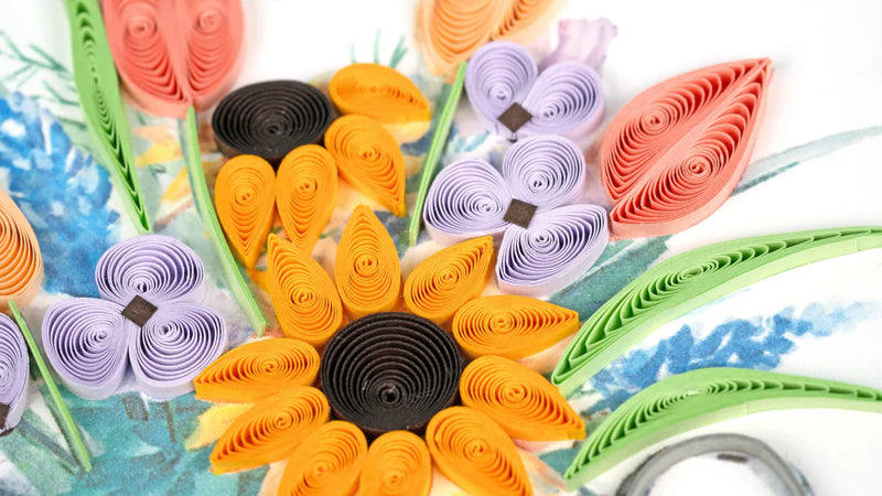 Quilled card with a silver watering can overflowing with colorful flowers, symbolizing joy and growth in a cheerful garden theme.