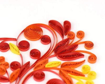 Quilled greeting card featuring a large heart made of red, pink, and gold swirls and floral patterns. Romantic handmade art card.