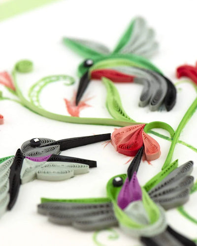 Quilled card with three hummingbirds flying around red flowers and green vines, symbolizing love, energy, and spiritual connection.