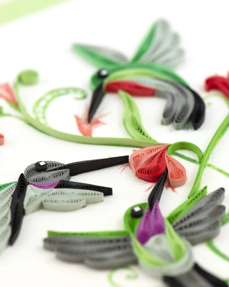 Quilled card with three hummingbirds flying around red flowers and green vines, symbolizing love, energy, and spiritual connection.