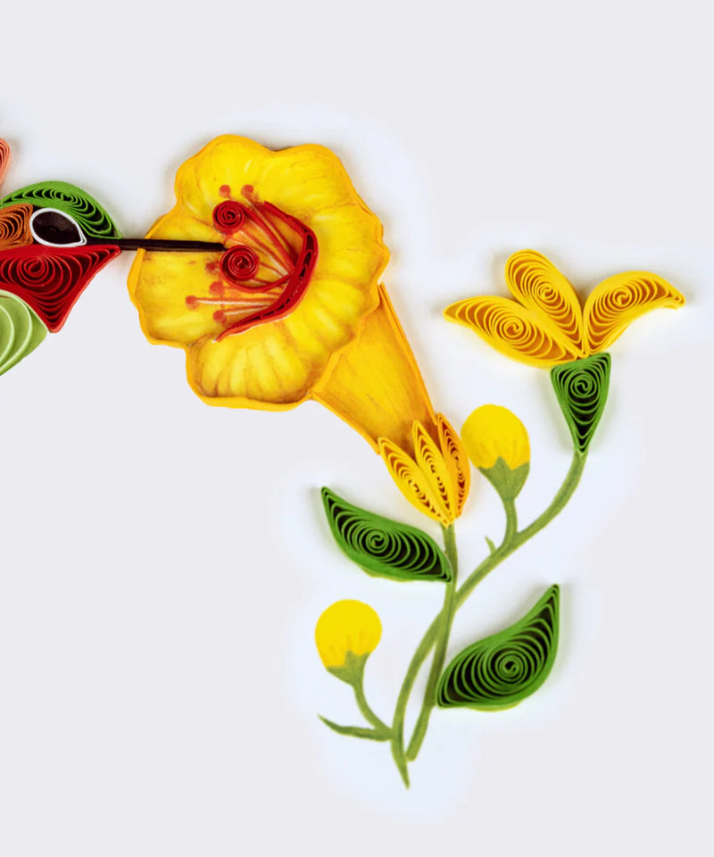 Handcrafted quilled card showing a hummingbird sipping nectar from vibrant yellow flowers, symbolizing beauty, energy, and joy.