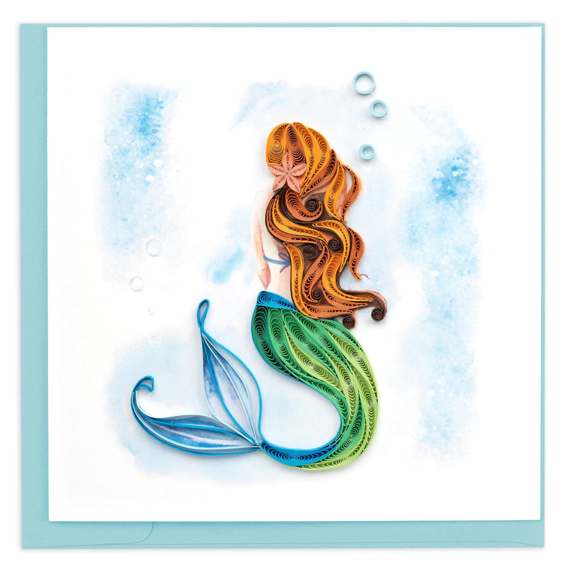 Quilled greeting card with a mermaid in flowing red hair and green tail, swimming among blue bubbles against a soft ocean background.