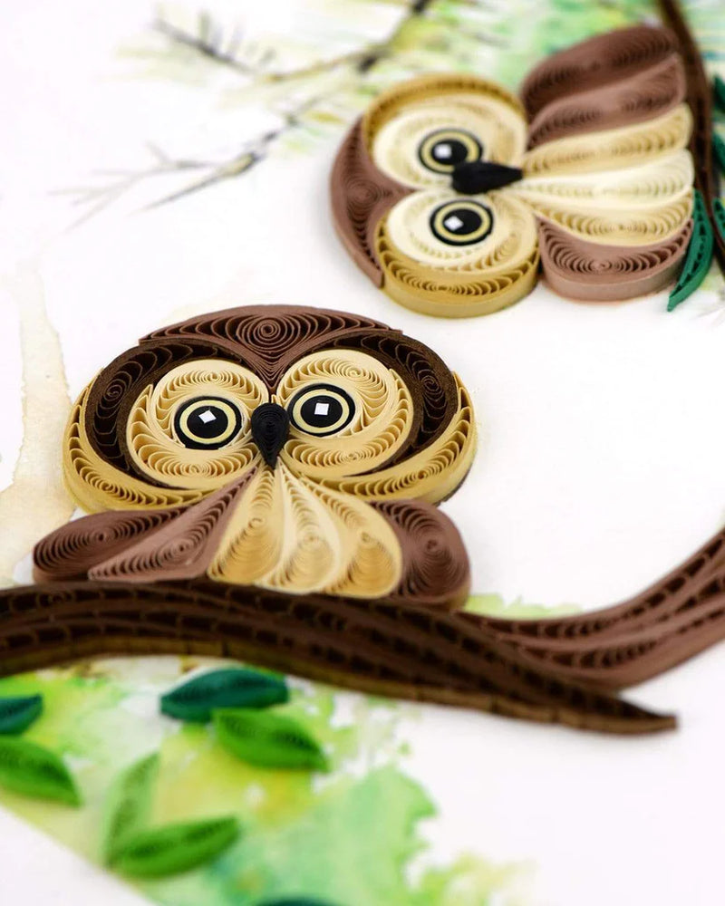 Quilled card with two brown owlets perched on leafy green branches, symbolizing wisdom, protection, and sweet friendship.