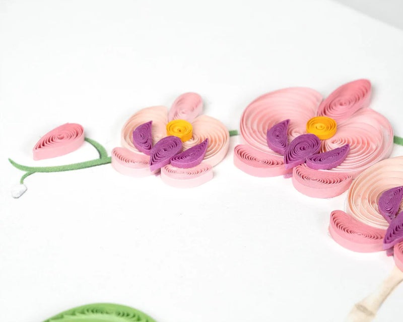 Handcrafted quilled greeting card featuring a pink orchid in full bloom, set in a blue polka dot pot with vibrant green leaves.