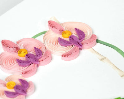 Handcrafted quilled greeting card featuring a pink orchid in full bloom, set in a blue polka dot pot with vibrant green leaves.