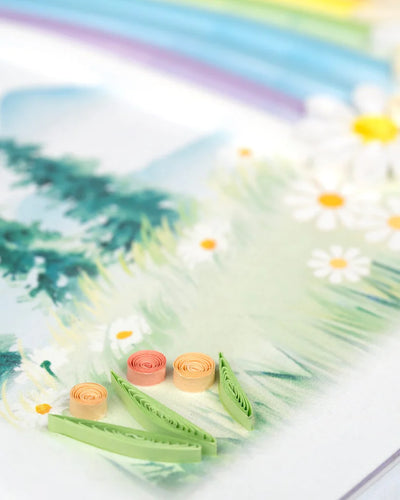 Quilled card with a rainbow arching over a mountain landscape and colorful flowers in the foreground. Symbol of hope and new beginnings.