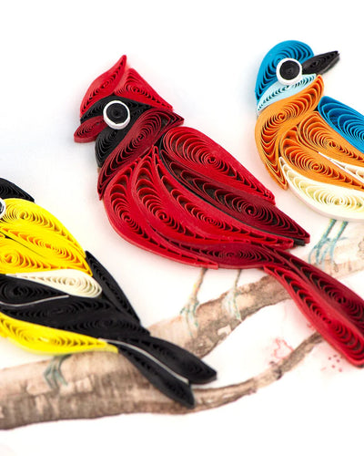 Quilled card with five colorful birds, including a cardinal and hummingbird, perched on a branch—symbolizing joy, unity, and nature's song.