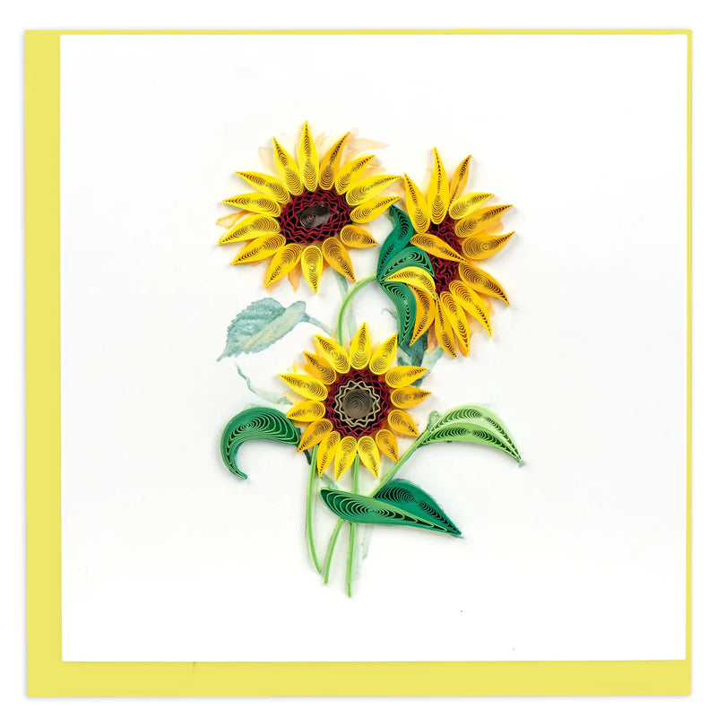 Hand-quilled greeting card featuring two blooming yellow sunflowers with green leaves, framed in soft yellow border on white background.