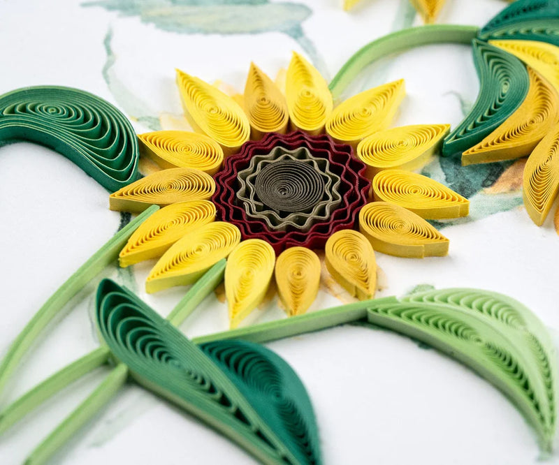 Hand-quilled greeting card featuring two blooming yellow sunflowers with green leaves, framed in soft yellow border on white background.