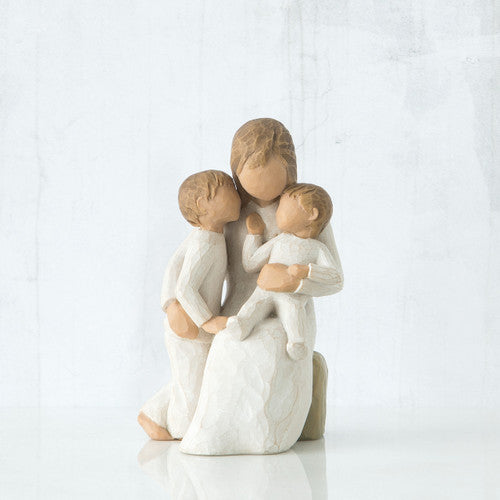 Willow Tree Quietly figurine of mother seated with toddler in arms and older child standing beside her, all in cream outfits.

