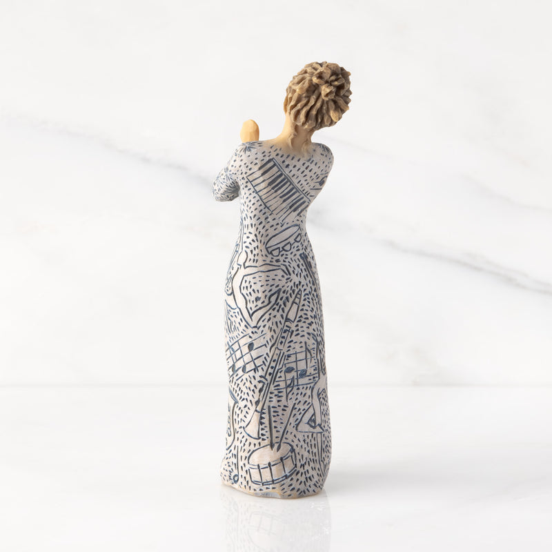 Willow Tree Music Speaks figurine with lighter skin featuring a dress carved with musical symbols and dancing figures.