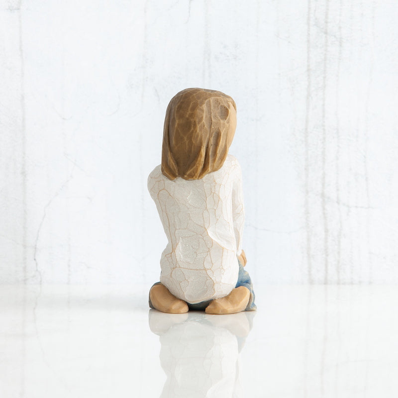 Willow Tree Joyful Child figurine of kneeling girl with arms folded on knees.