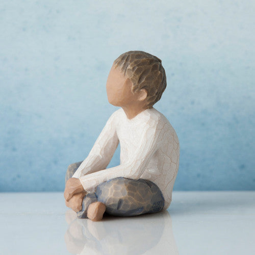 Willow Tree Imaginative Child figurine of seated boy with darker skin tone and hair.
