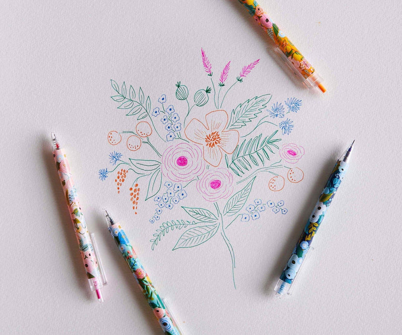 Set of four Rifle Paper Co. Garden Party gel pens with floral patterns and bright ink colors in pink, orange, green, and blue.