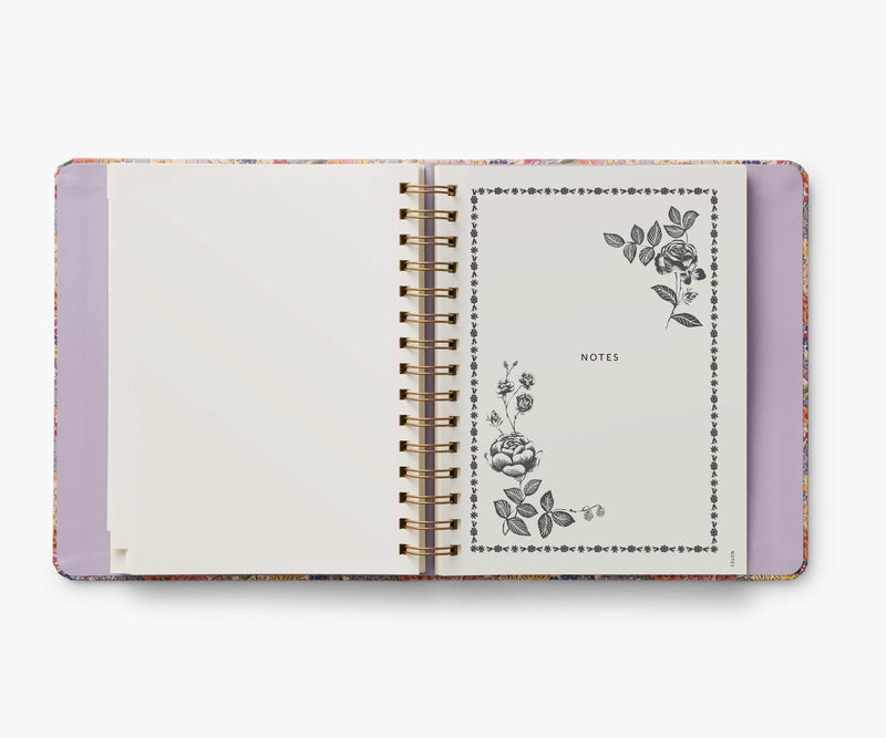 Rifle Paper Co. Mimi 2024–2025 planner with floral cover, gold foil accents, weekly and monthly views, stickers, and storage folders.