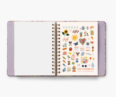 Rifle Paper Co. Mimi 2024–2025 planner with floral cover, gold foil accents, weekly and monthly views, stickers, and storage folders.