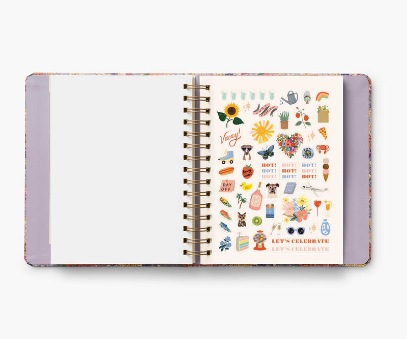 Rifle Paper Co. Mimi 2024–2025 planner with floral cover, gold foil accents, weekly and monthly views, stickers, and storage folders.