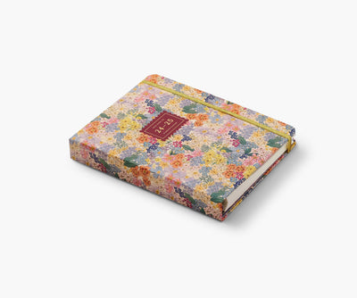 Rifle Paper Co. Mimi 2024–2025 planner with floral cover, gold foil accents, weekly and monthly views, stickers, and storage folders.