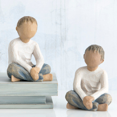 Willow Tree Imaginative Child figurine of seated boy with darker skin tone and hair.