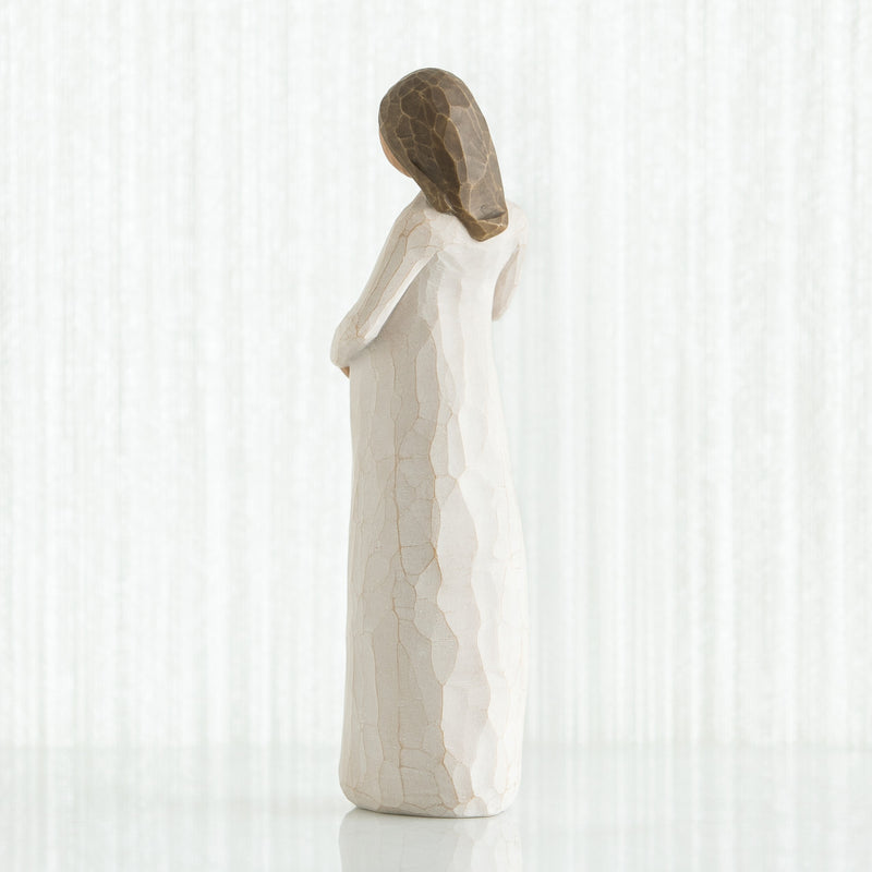 Willow Tree Cherish figurine of pregnant woman in cream dress with hands on belly.