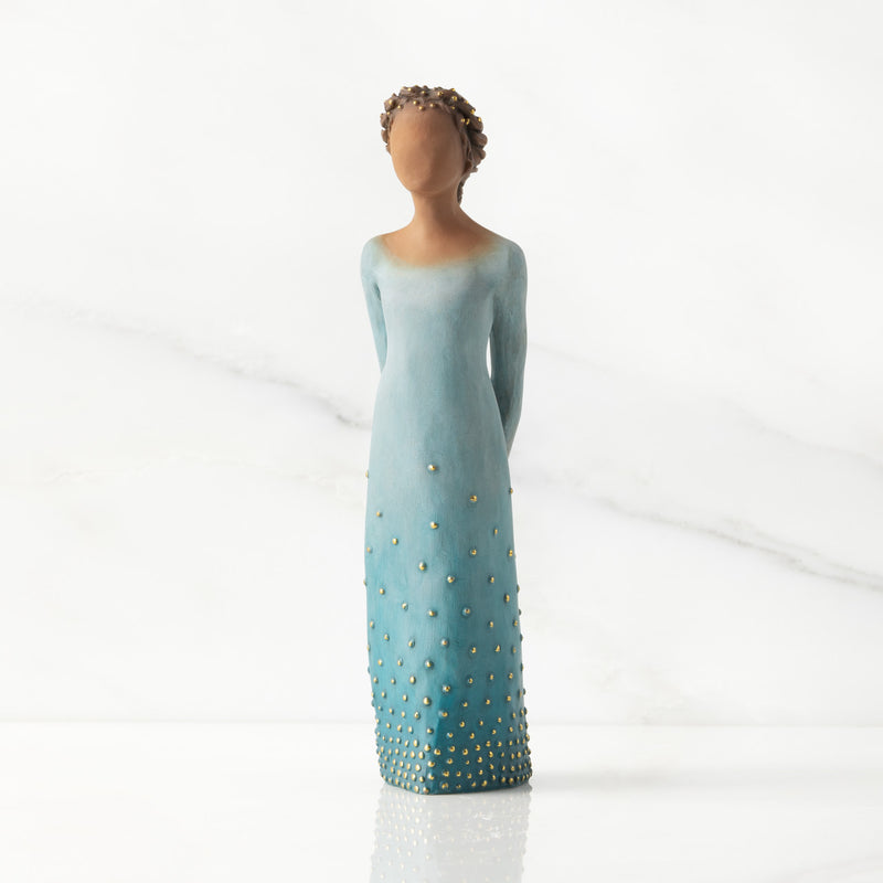 Willow Tree Radiance figurine with darker skin in a deep blue ombré dress dotted with gold leaf.