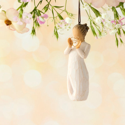 Willow Tree 2025 Ornament figurine in cream dress holding a golden wire heart with 2025 inside, hanging by a brown cord.