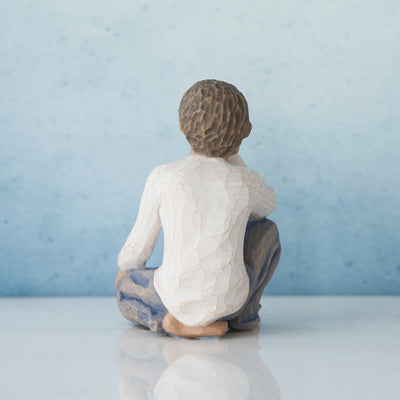 Willow Tree Inquisitive Child figurine of kneeling boy with darker skin tone and hair.