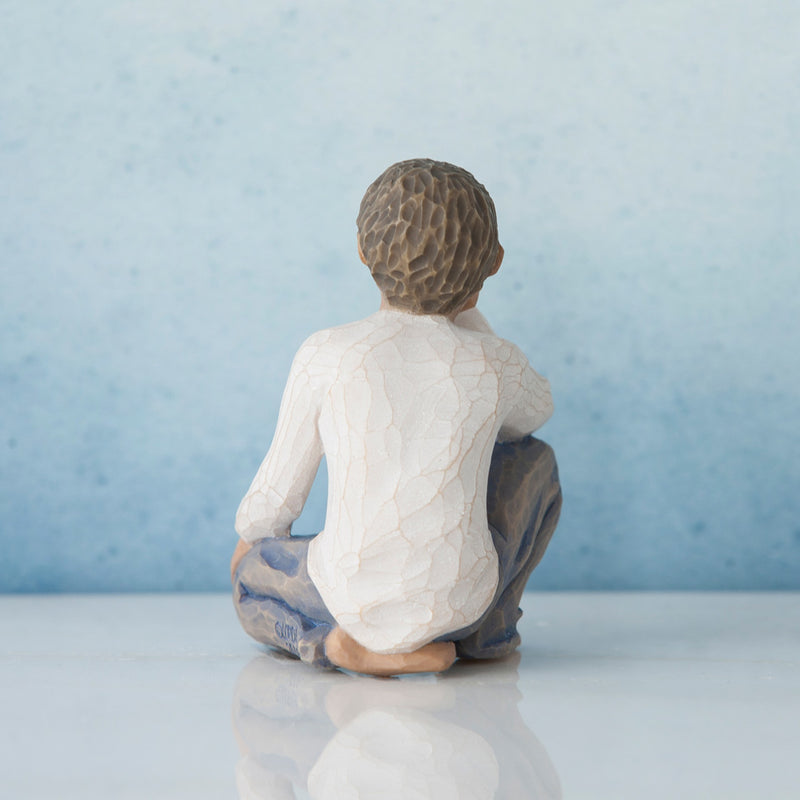 Willow Tree Inquisitive Child figurine of kneeling boy with darker skin tone and hair.