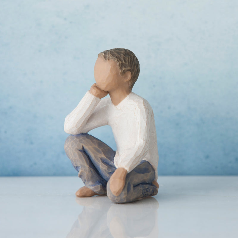 Willow Tree Inquisitive Child figurine of kneeling boy with darker skin tone and hair.