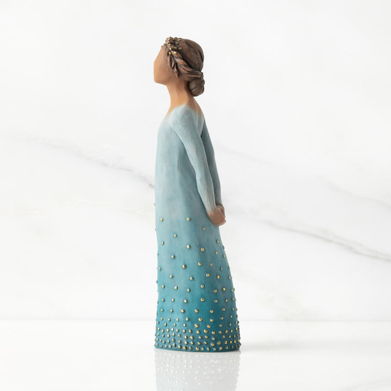 Willow Tree Radiance figurine with darker skin in a deep blue ombré dress dotted with gold leaf.