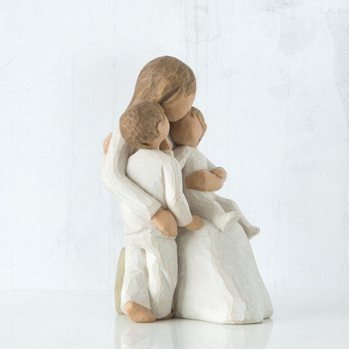 Willow Tree Quietly figurine of mother seated with toddler in arms and older child standing beside her, all in cream outfits.
