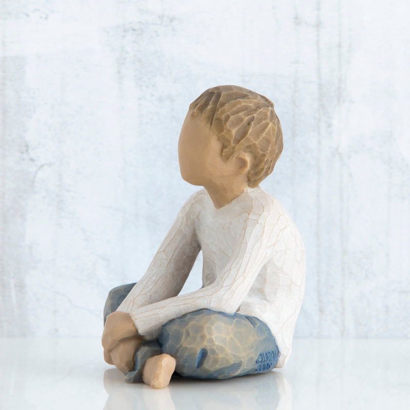 Willow Tree Imaginative Child figurine seated cross-legged with arms folded in lap.