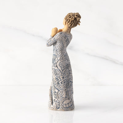 Willow Tree Music Speaks figurine with lighter skin featuring a dress carved with musical symbols and dancing figures.