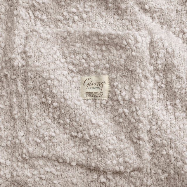 Ivory-colored soft giving shawl with a knitted texture, packaged for gifting, designed to provide comfort and warmth.