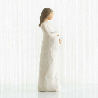 Willow Tree Cherish figurine of pregnant woman in cream dress with hands on belly.