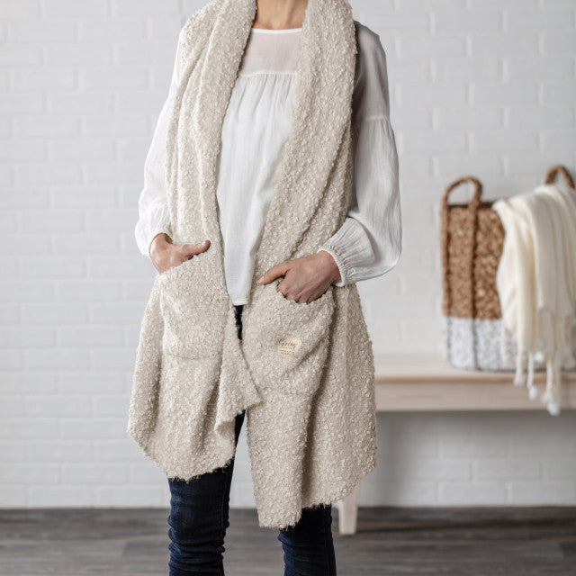 Ivory-colored soft giving shawl with a knitted texture, packaged for gifting, designed to provide comfort and warmth.