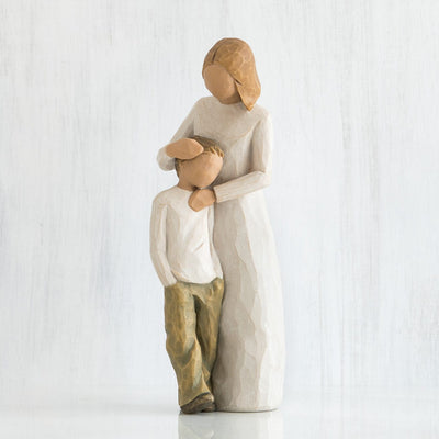 Mother and Son, Willow Tree, with standing figure in cream dress, with arms around young boy in cream shirt and dark pants.