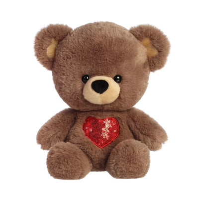 brown teddy bear with a red sequined heart sewn on its chest