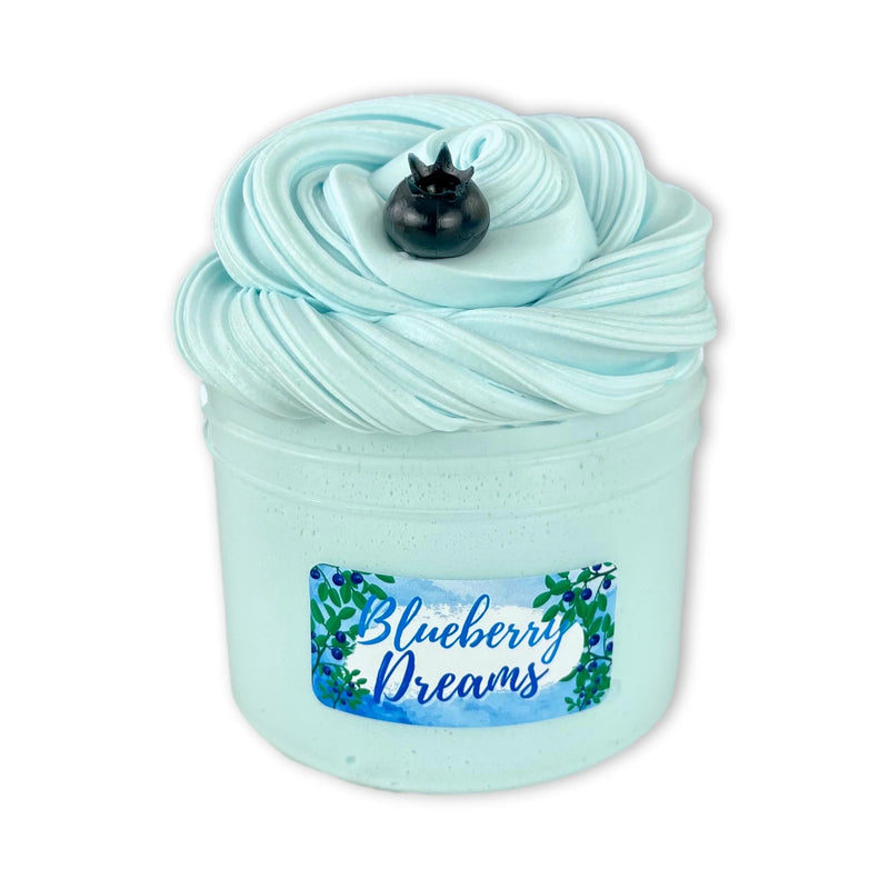 Container of Blueberry Dreams slime by Dope Slimes. Light blue slime with a fake blueberry on top