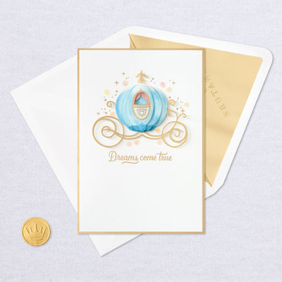 Blank greeting card features a layered, dimensional attachment of Cinderella's carriage with gold foil