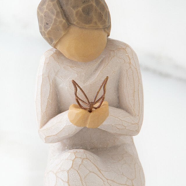 hand-painted resin figure in cream dress, kneeling with a gold leaf wire butterfly alighted